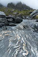 Folded quartz layers in schist, Clarke River at Marks Flat, Hooker - Landsborough Wilderness Area, Southern Alps, New Zealand.